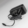 Black power adapter with cable on a white background