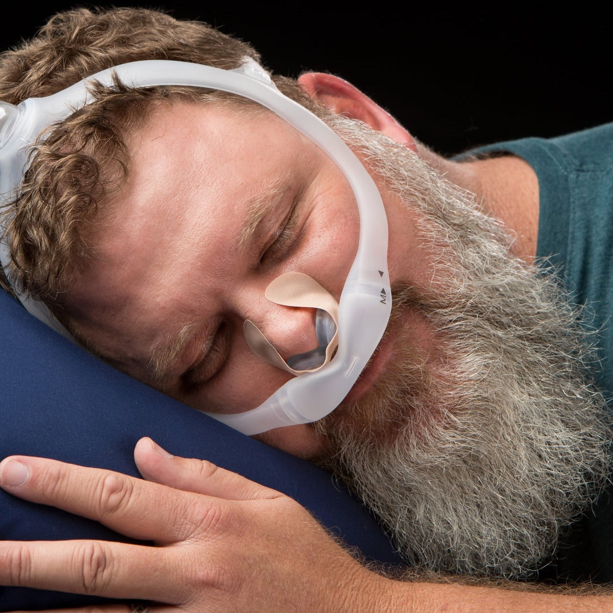 Man wearing a nasal pillow mask with nozseal adhesive strips