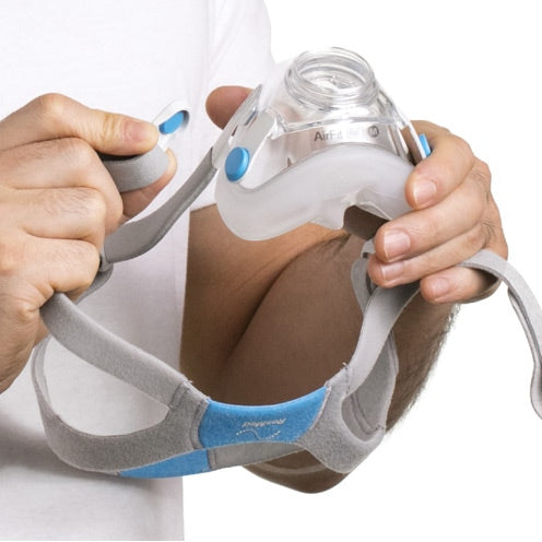 Person holding a CPAP mask with a white background