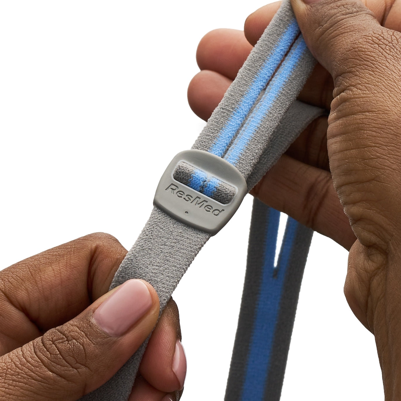 Gray and blue strap with ResMed logo held by a hand on a white background