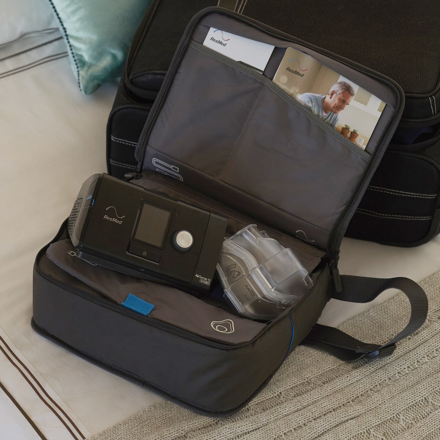 AirSense 10 CPAP machine in a travel bag on a bed