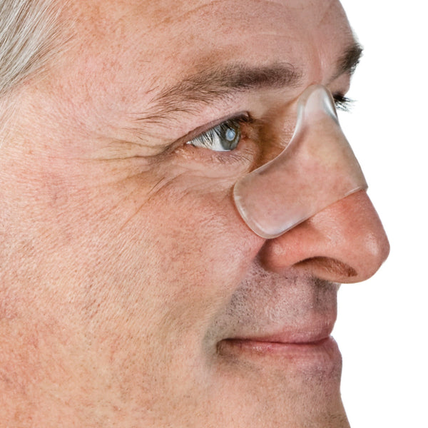 Close-up of a person wearing a clear gecko gel nasal cpap pad  on a white background