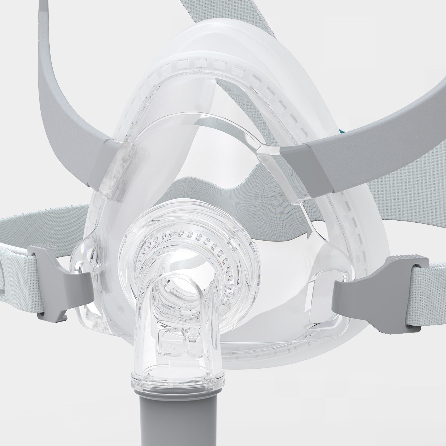 Close-up of a clear CPAP mask with gray straps on a light gray background