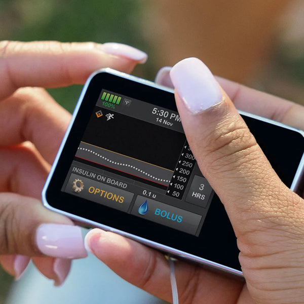 Person holding a digital device with a screen displaying insulin pump settings.