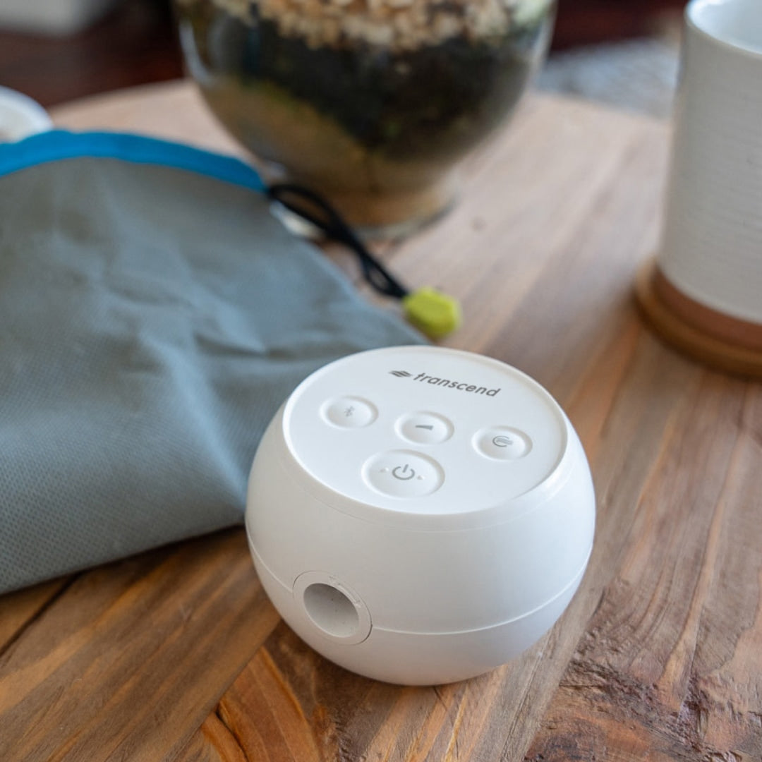White electronic device with buttons on a wooden surface, featuring the brand 'Transcend'.