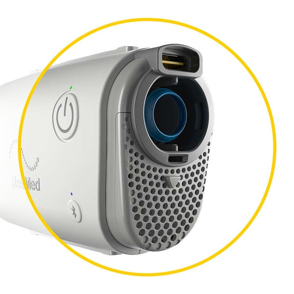 Side view of a Resmed CPAP machine with a yellow circle around where the filter goes